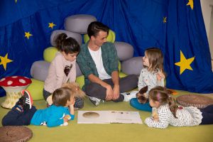 Kinder schauen sich ein Bilderbuch an