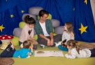 Kinder schauen sich ein Bilderbuch an