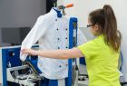 Schüler bedient eine Bügelmaschine